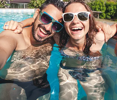 Couple enjoying luxury backyard pool with stylish outdoor living space