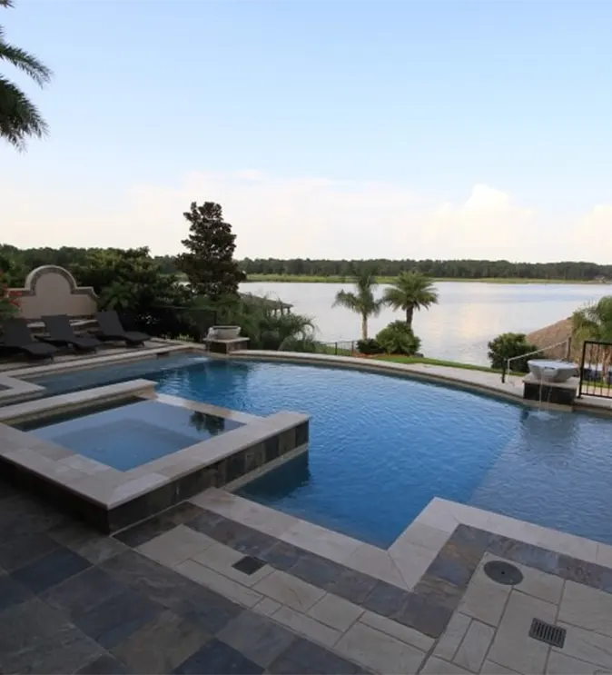 Luxury backyard pool with spa and waterfront view showcasing custom pool design and outdoor living spaces