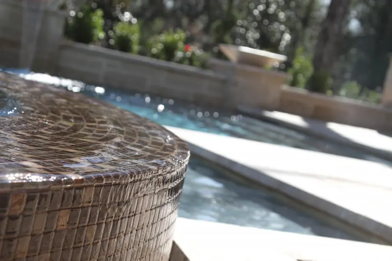 Glass tile spa with water features in luxury backyard pool setting